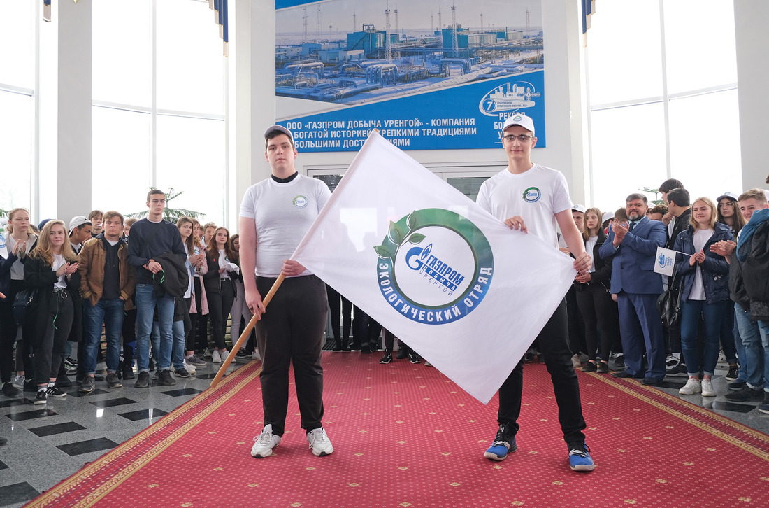 Представители первой смены передают флаг с эмблемой Экологических отрядов ООО "Газпром добыча Уренгой" своим преемникам