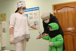 Старшая медицинская сестра Альбина Шайбакова измеряет температуру на входе в детский сад